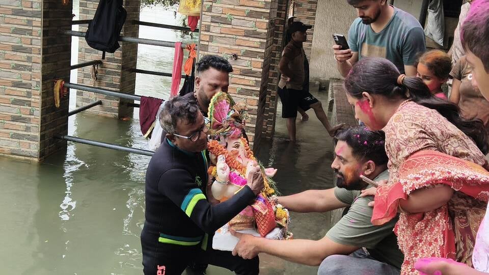 विसर्जन करने से पहले गणेश के कान में मन्नत बताती छोटी बच्ची। अशोक कुमार विसर्जन करने से पहले गणेश के कान में मन्नत बताती छोटी बच्ची। अशोक कुमार