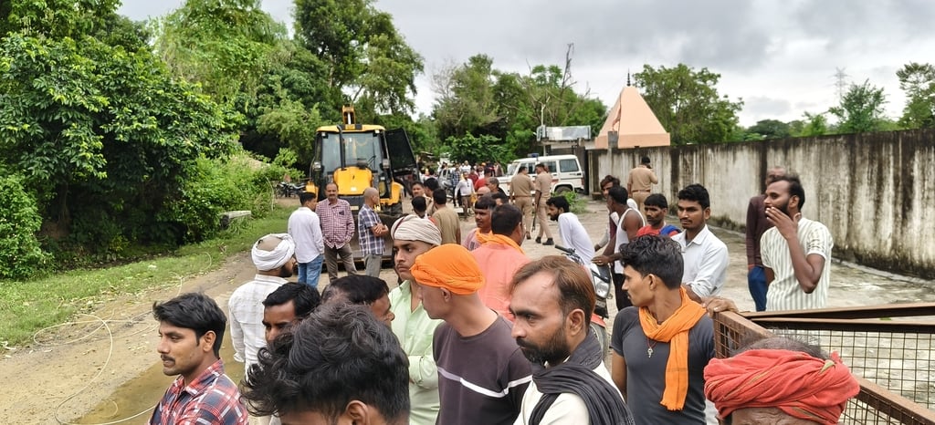 घायल अभिषेक और प्रदर्शन करते ग्रामीण।