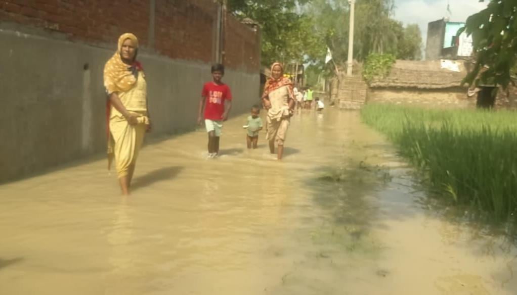 महिलाओं को रेस्क्यू कर नाव से उतारते एसडीआरएफ कर्मी व वीरपुर गांव में भरे पानी के बीच से निकलत महिलाओं को रेस्क्यू कर नाव से उतारते एसडीआरएफ कर्मी व वीरपुर गांव में भरे पानी के बीच से निकलत
