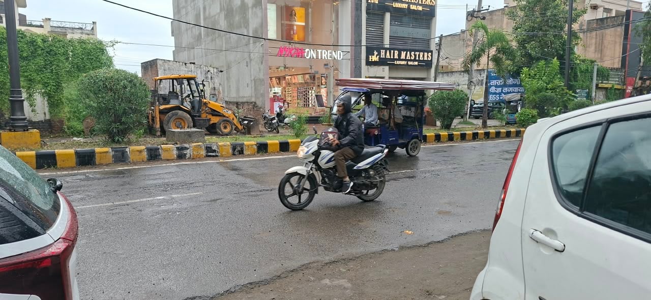 बारिश के दौरान शहर की गोबिंदपुरी रोड से गुजरते लोग। संवाद बारिश के दौरान शहर की गोबिंदपुरी रोड से गुजरते लोग। संवाद