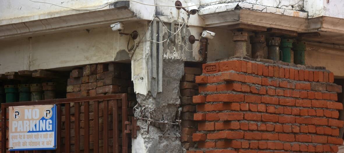 अपार्टमेंट के बाहर जुटे लोग और मरम्मत करते श्रमिक। अपार्टमेंट के बाहर जुटे लोग और मरम्मत करते श्रमिक।