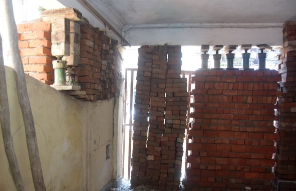 अपार्टमेंट के बाहर जुटे लोग और मरम्मत करते श्रमिक। अपार्टमेंट के बाहर जुटे लोग और मरम्मत करते श्रमिक।