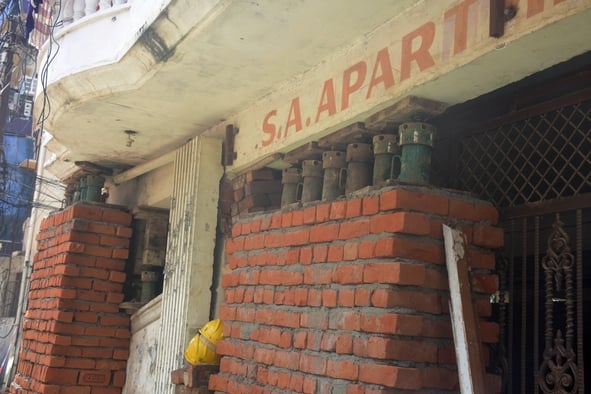 फलैट के बाहर जुटे लोग और काम करते श्रमिक। फलैट के बाहर जुटे लोग और काम करते श्रमिक।