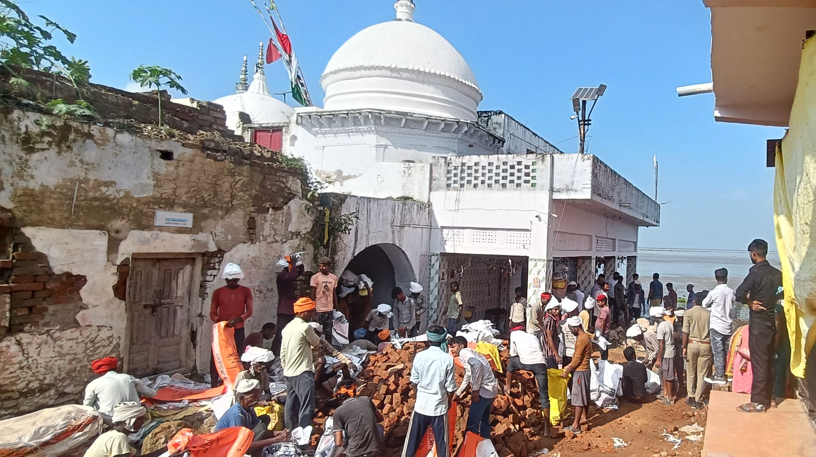 हेतमापुर में बाबा नारायणदास धाम को बचाने के लिए कटान रोकने में लगे ग्रामीण।
