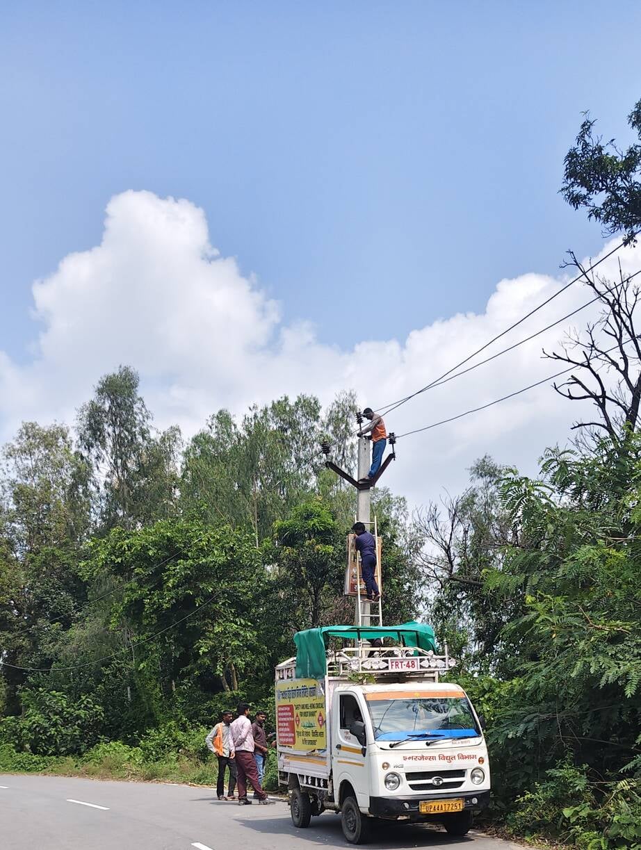 कोटवाधाम में मालवाहन पर चढ़कर लाइन ठीक करते विद्युत कर्मी। कोटवाधाम में मालवाहन पर चढ़कर लाइन ठीक करते विद्युत कर्मी।