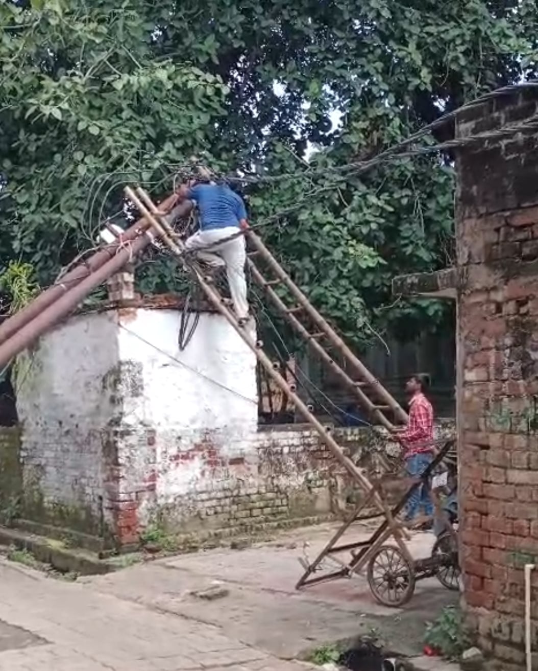 खंभा सही करते बिजली कर्मी।