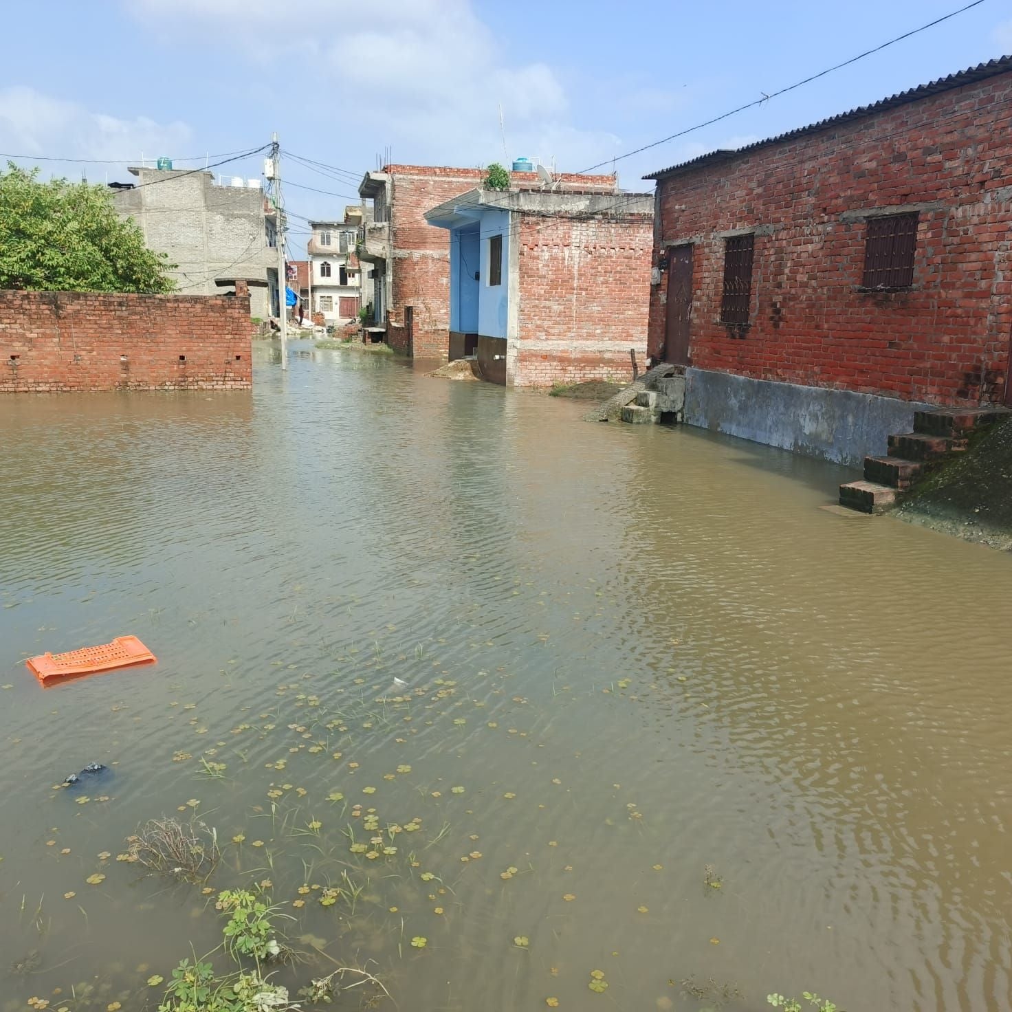 शिवनगर में भरे पानी में नाव से आवागमन करते बच्चे व महिला। संवाद