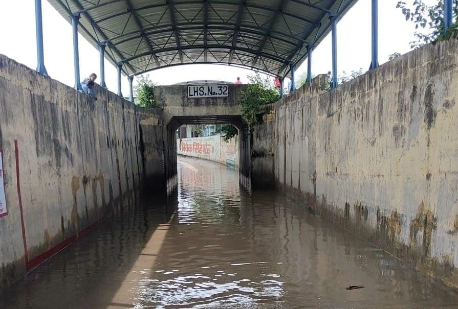शिवनगर में भरे पानी में नाव से आवागमन करते बच्चे व महिला। संवाद
