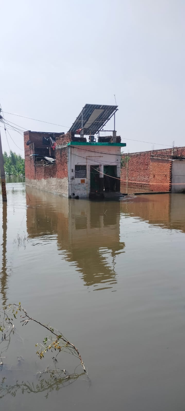 जलालाबाद में तिकोला घाट के आगे पानी में डूबी पुलिया से बाइक लेकर निकलता युवक। संवाद