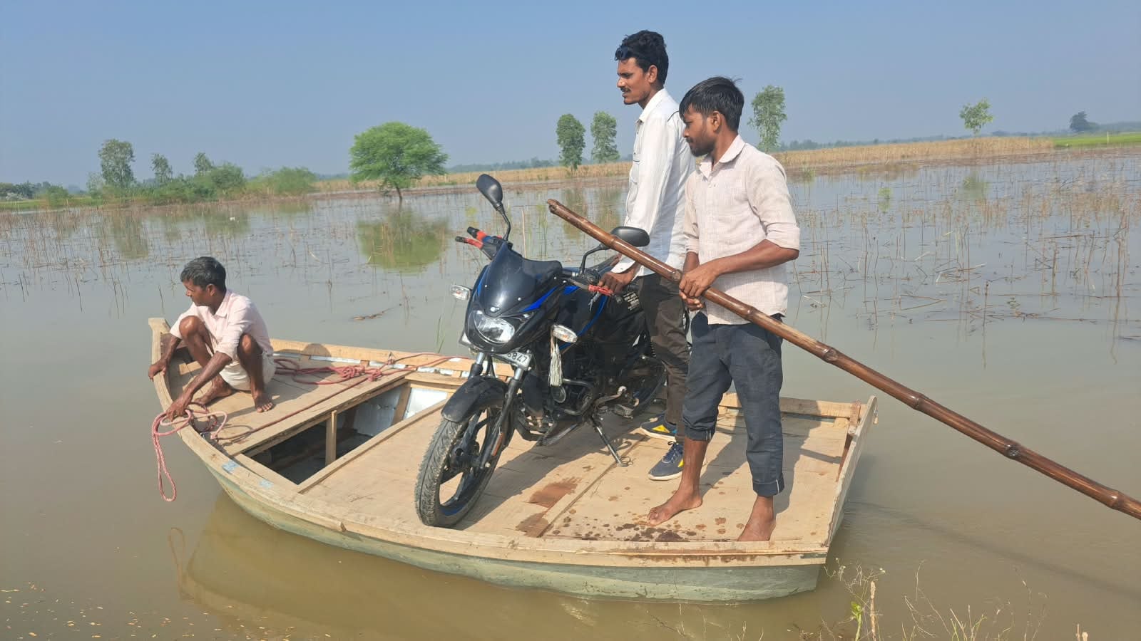 जलालाबाद में तिकोला घाट के आगे पानी में डूबी पुलिया से बाइक लेकर निकलता युवक। संवाद