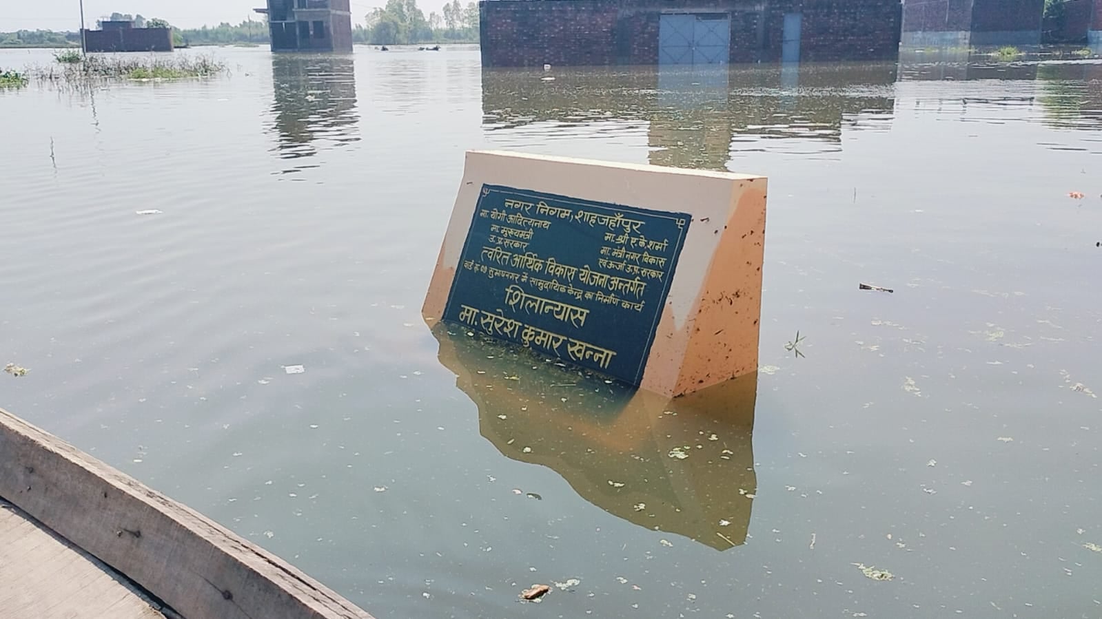 जलालाबाद में तिकोला घाट के आगे पानी में डूबी पुलिया से बाइक लेकर निकलता युवक। संवाद
