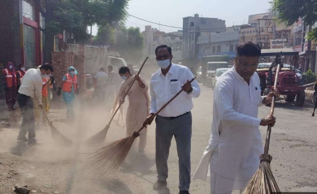 पार्क में झाडू लगाते अधिकारी व कर्मचारी। विज्ञप्ति