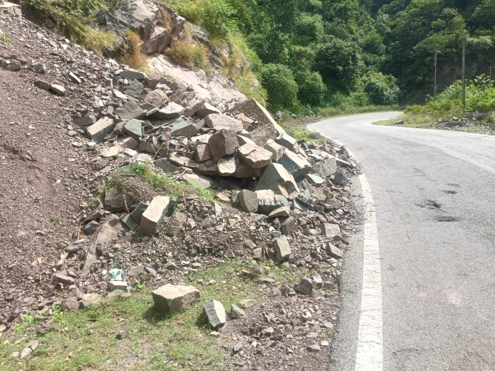 नाहन-कुमारहट्टी एनएच पर चबाहां के पास सड़क पर पड़ा पत्थर और मलबे का ढेर। संवाद