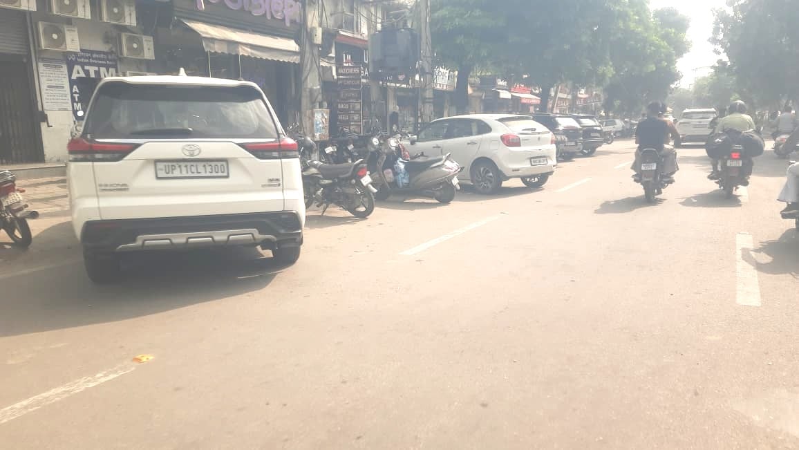 जिला अस्पताल के सामने सड़क के बीच गाड़ी खड़ी करवाकर पंचर लगाता मिस्त्री। संवाद