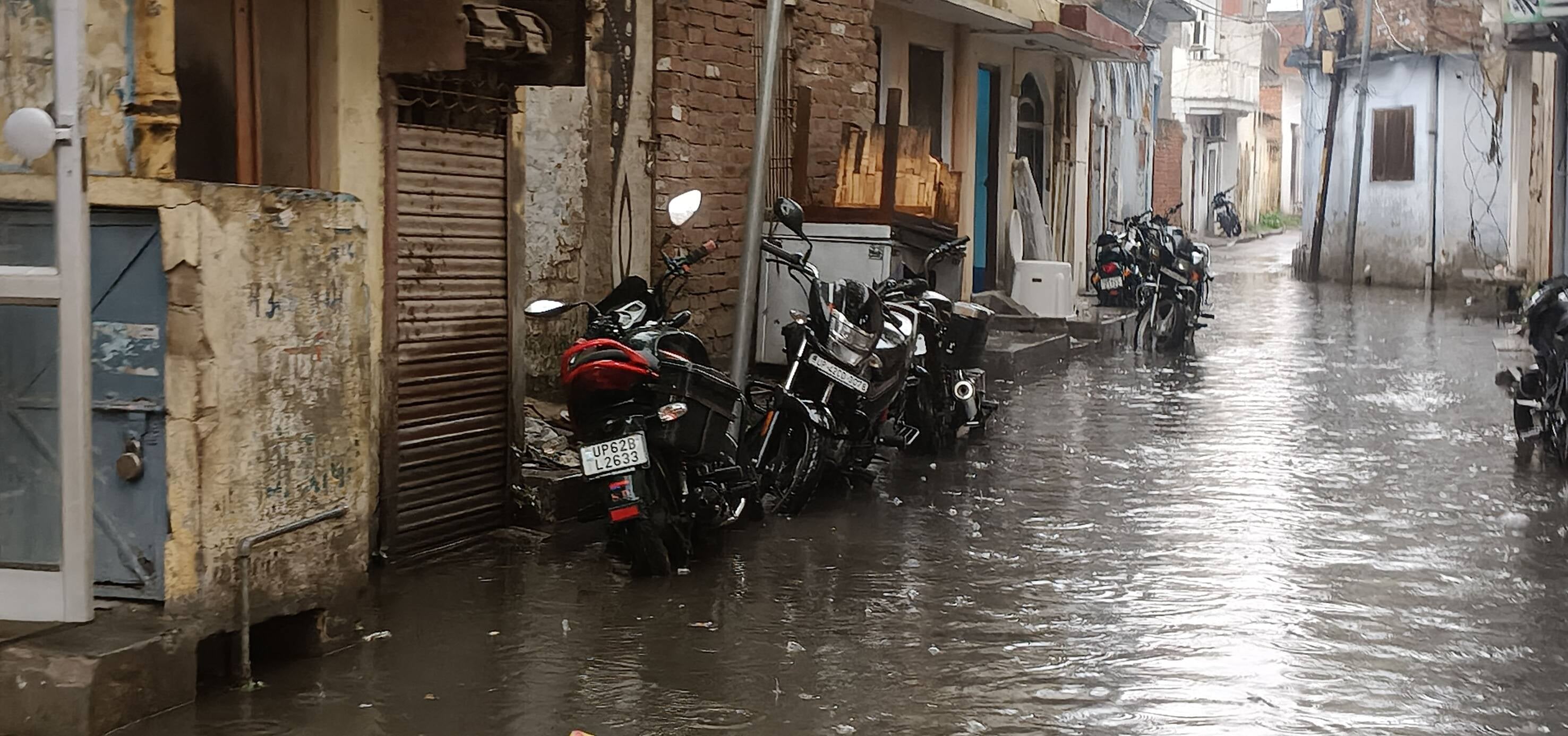 51-रिकाबगंज मुख्य मार्ग पर बारिश के दौरान हुए जलभराव से होकर गुजरता छात्र।-संवाद