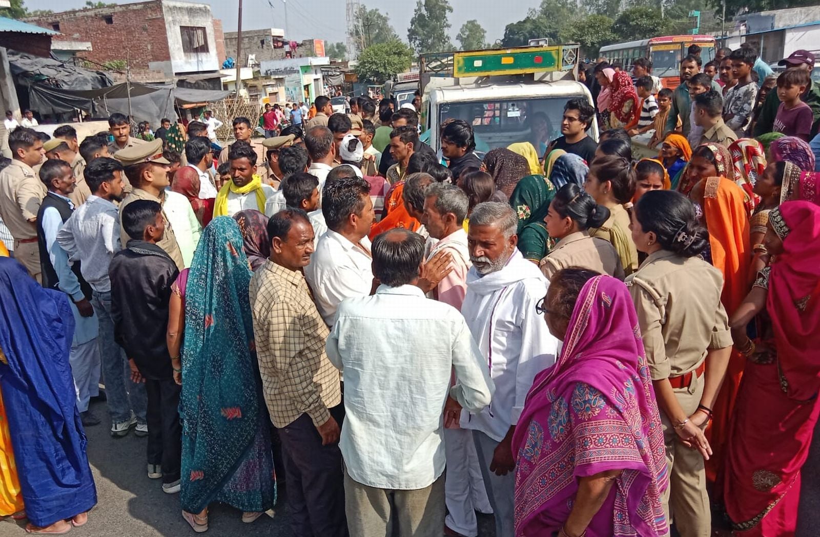 जाम लगाए परिवार की महिलाओं से बात करती पुलिस। संवाद