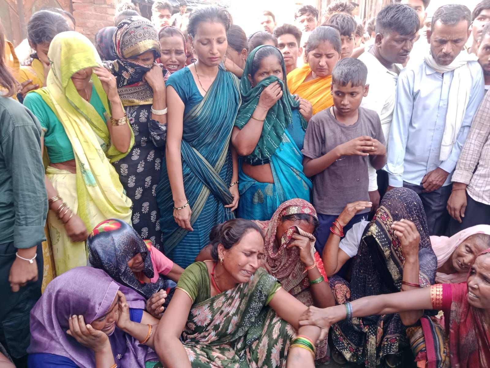 जाम लगाए परिवार की महिलाओं से बात करती पुलिस। संवाद