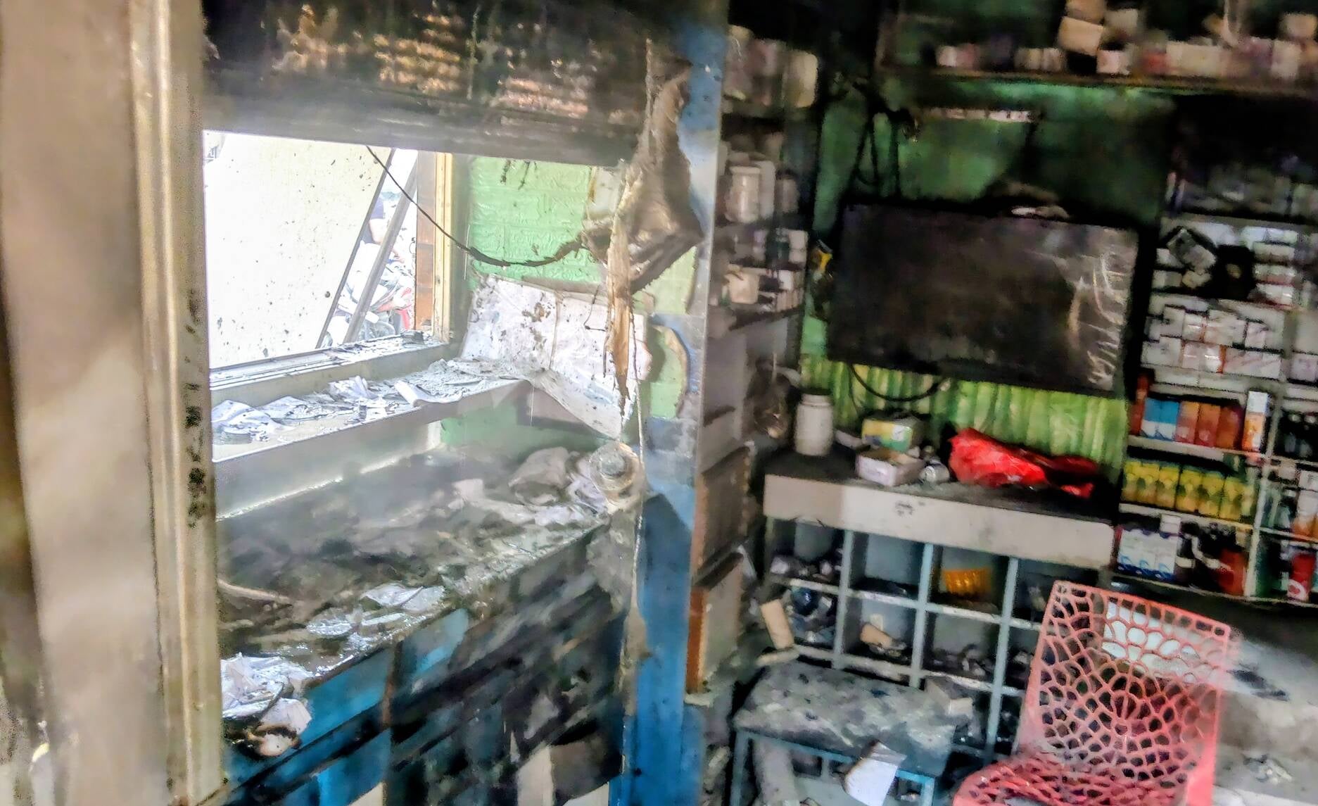 मैडिकल स्टोर में लगी आग को बुझाता फायर कर्मी। (मवाना)
