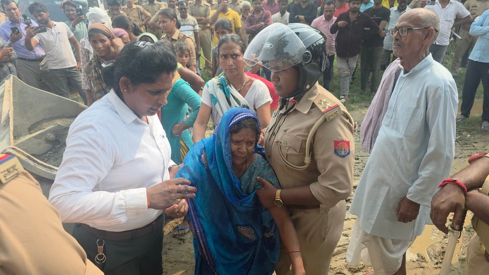 अकबरपुर के गौहन्ना के बबुरहिया गांव में जेसीबी मशीन को रोकतीं महिलाएं।