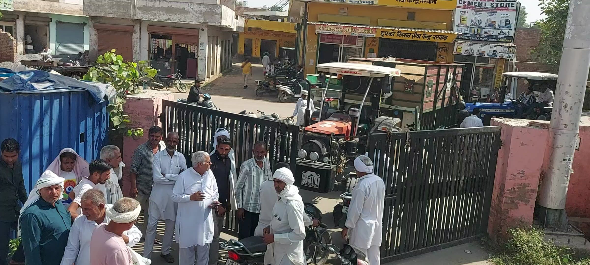 फोटो 2 नरवाना। नईं अनाज मेला मंडी के मुख्य गेट पर ताला लगाते हुए आढ़ती। संवाद।