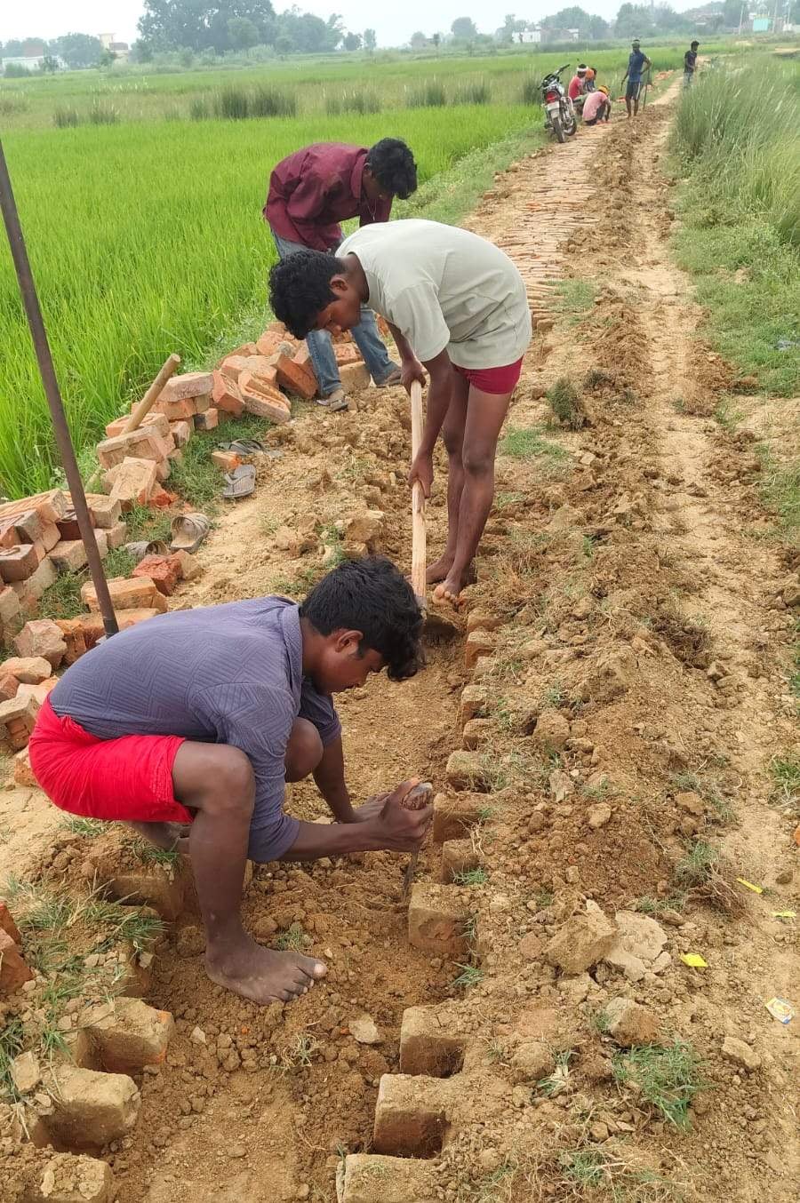 बरहनी विकासखंड के औरैया पट्टी गुलाल में खोदे गए सड़क की मरम्मत करते कर्मचारी। संवाद--- इम्पैक्ट