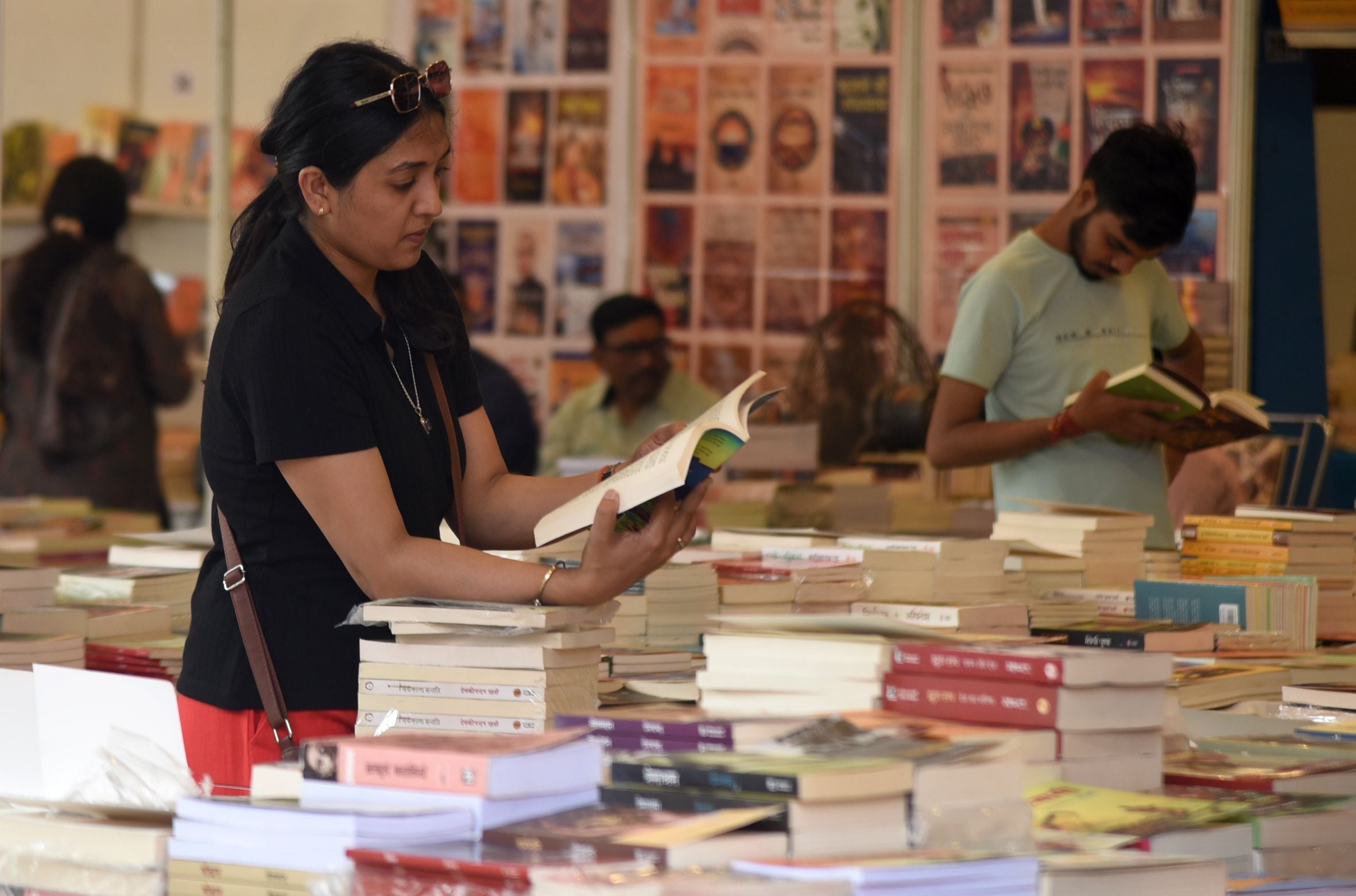 पुस्तक मेले में किताबें देखते लोग। पुस्तक मेले में किताबें देखते लोग।