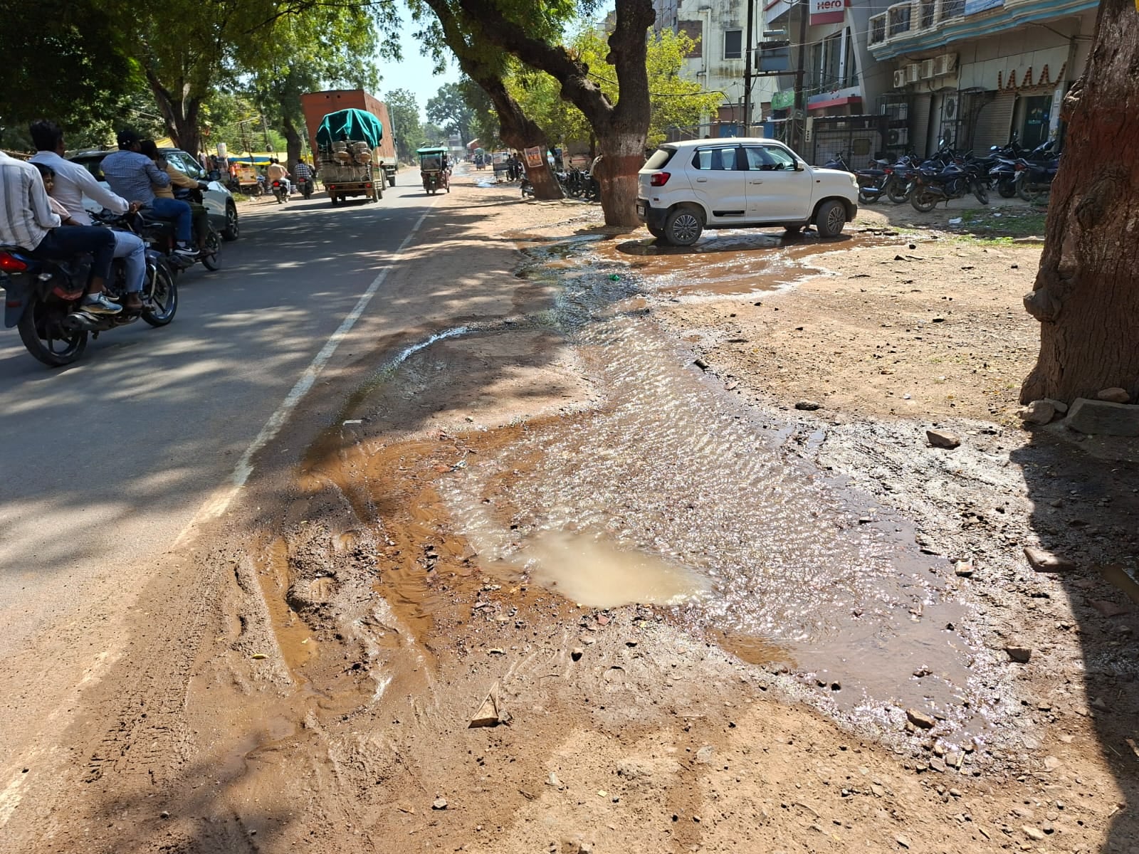 गल्ला मंडी के सामने पाइपलाइन लीकेज से गली में फैलता पानी व गहरे गड्ढे में धुसा बच्चे का पैर