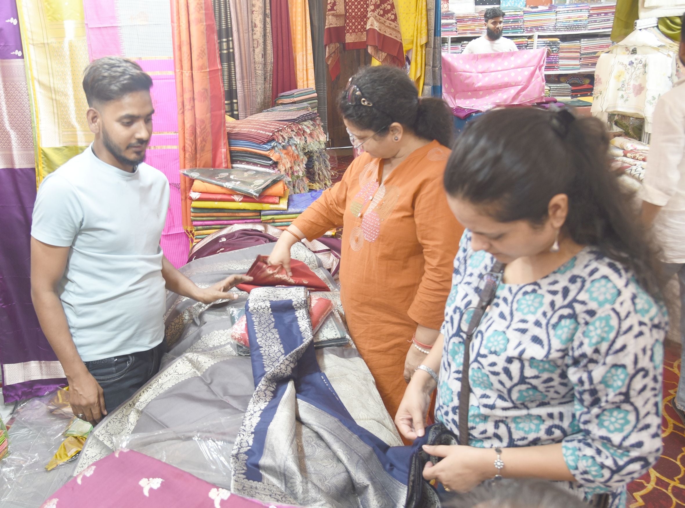कैसरबाग स्थित सफेद बारादरी में आयोजित कॉटन एंड सिल्क फैब प्रदर्शनी में कपड़े पसंद करतीं महिलाएं