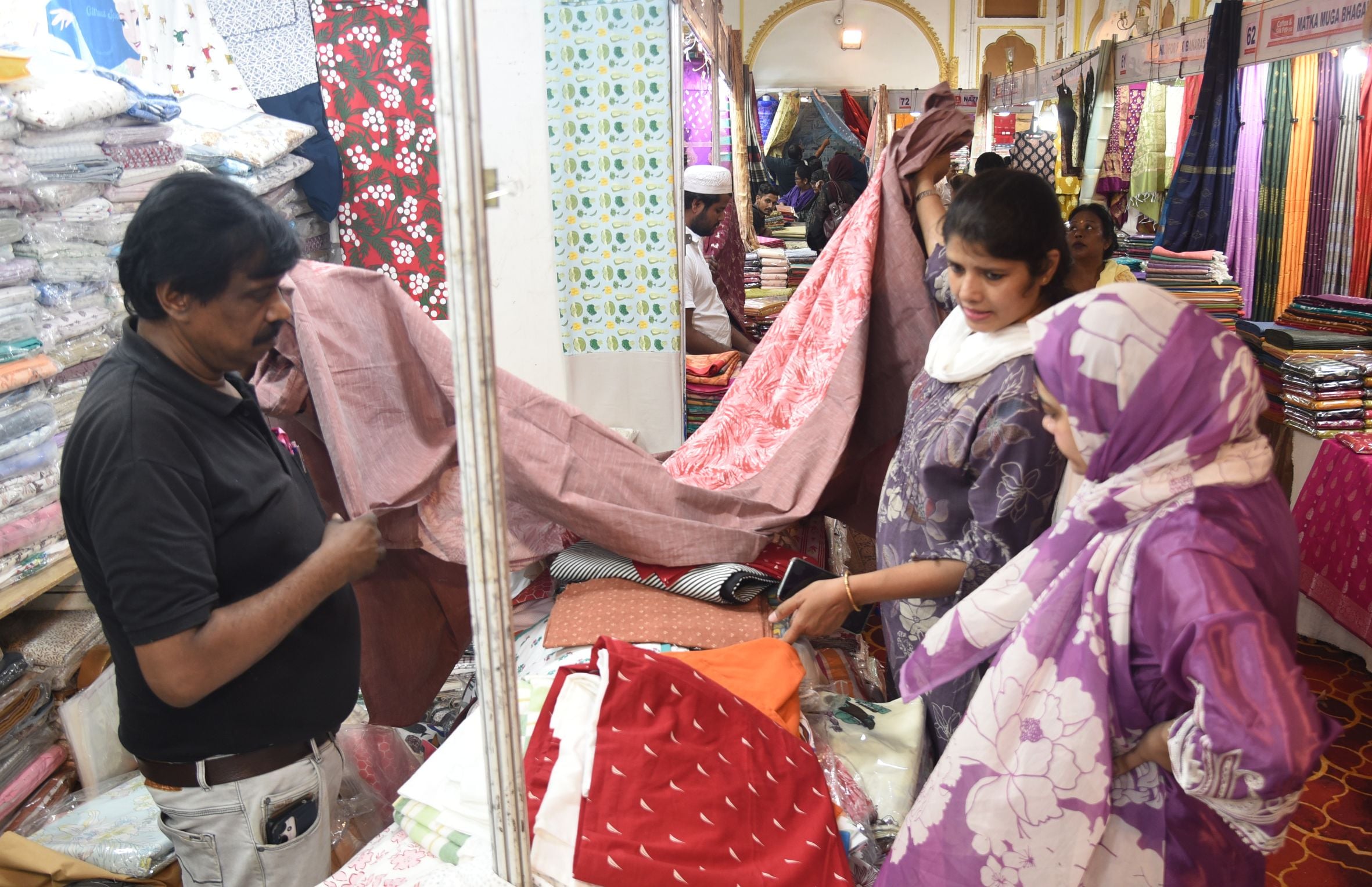 कैसरबाग स्थित सफेद बारादरी में आयोजित कॉटन एंड सिल्क फैब प्रदर्शनी में कपड़े पसंद करतीं महिलाएं