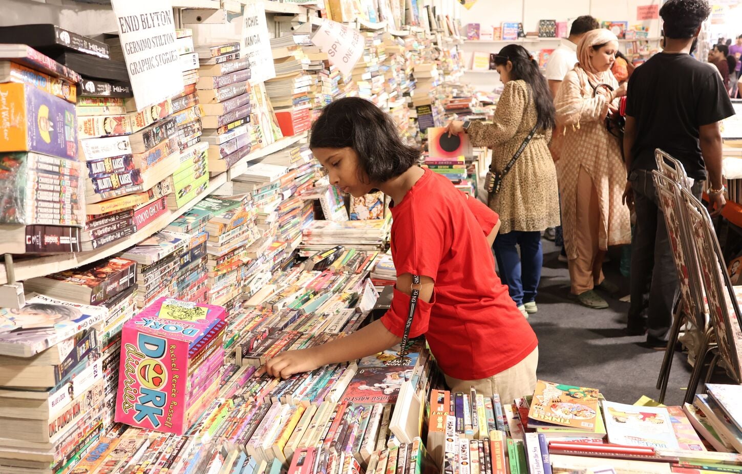 पुस्तक मेले में किताबें पसंद करते खरीदार। पुस्तक मेले में किताबें पसंद करते खरीदार।