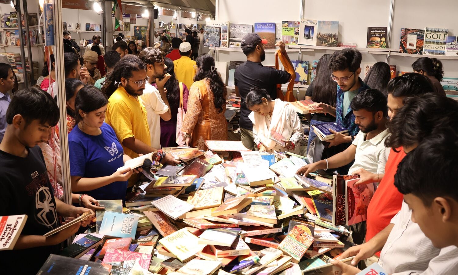 पुस्तक मेले में किताबें पसंद करते खरीदार। पुस्तक मेले में किताबें पसंद करते खरीदार।
