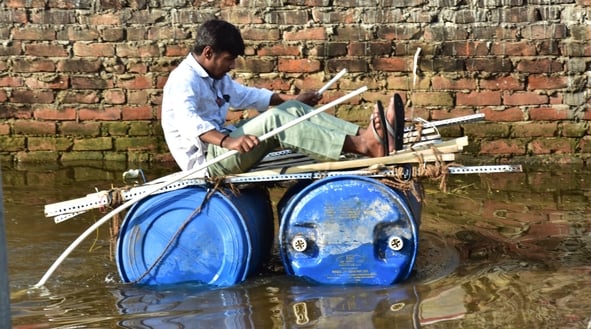 बोतलों को बोरी में भरकर बनाई जुगाड़ की नाव।