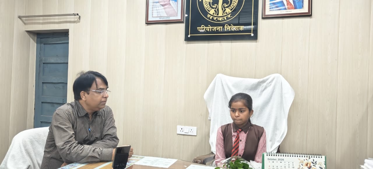 फोटो-34 विकास भवन सभागार में सीडीओ की कुर्सी पर बैठकर काम करती छात्रा अंशिका।