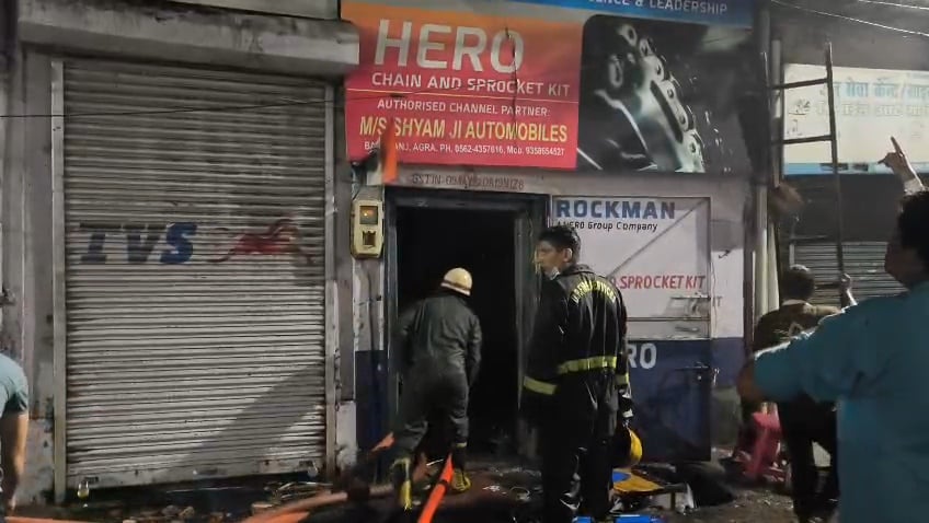 ऑटो पार्ट्स की दुकान में लगी आग दमकल कर्मी बुझाते हुए।