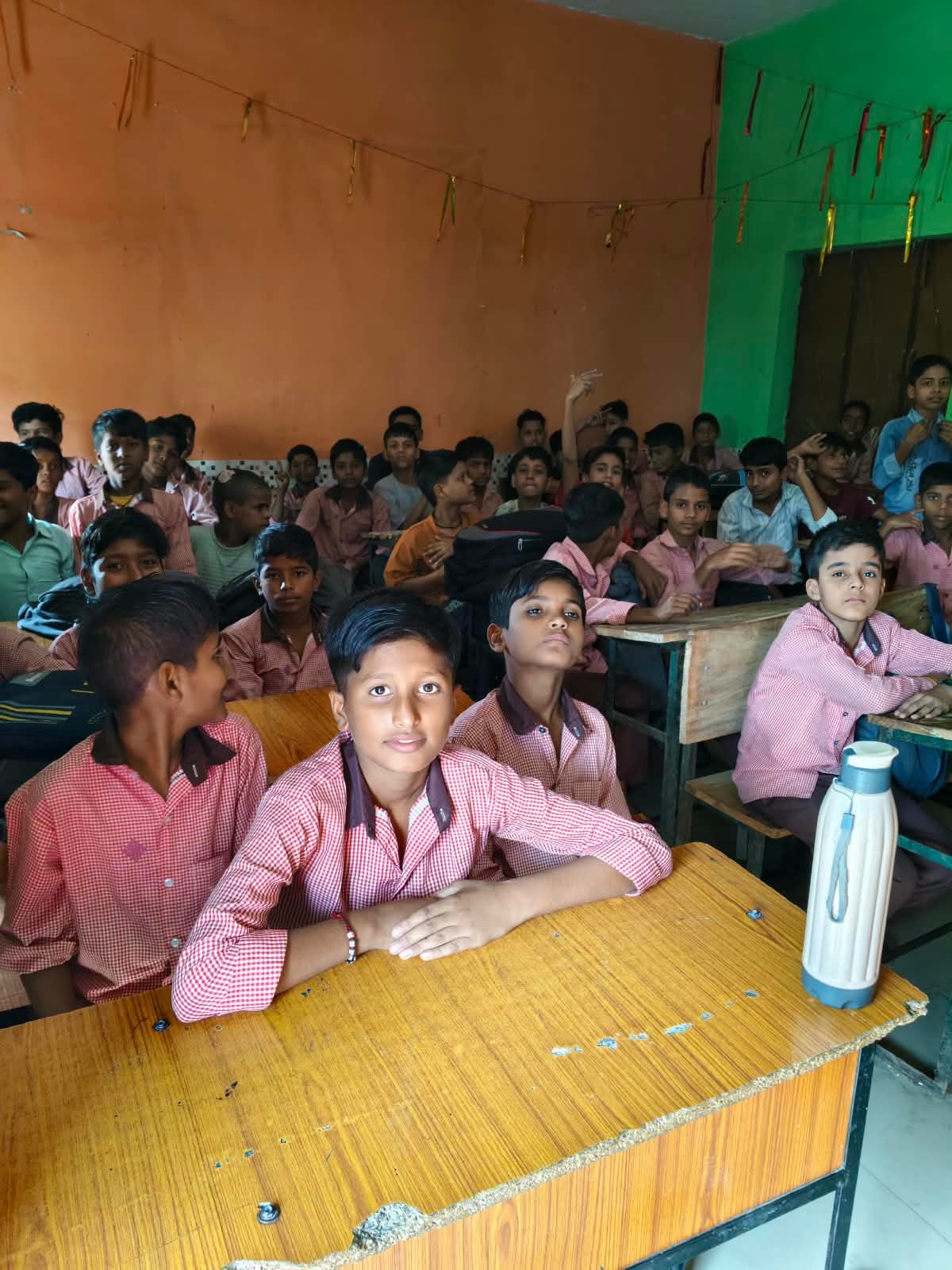 प्राथमिक विद्यालय अलाउदीनपुर का जर्जर भवन का ध्वस्तीकरण होने के बाद मजबूरी में खुले में चलती पढ