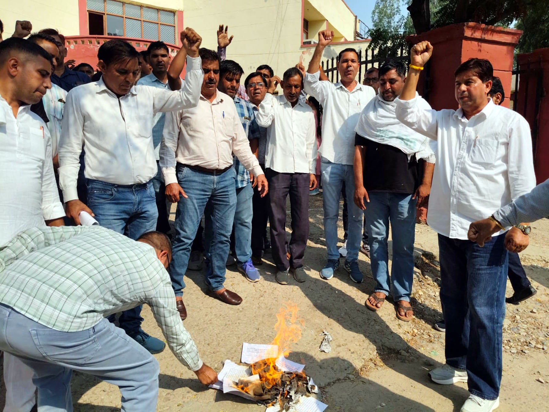 लाइसेंस की प्रतियां जलाकर रोष जताते बिजली विभाग के कर्मचारी। विज्ञप्ति