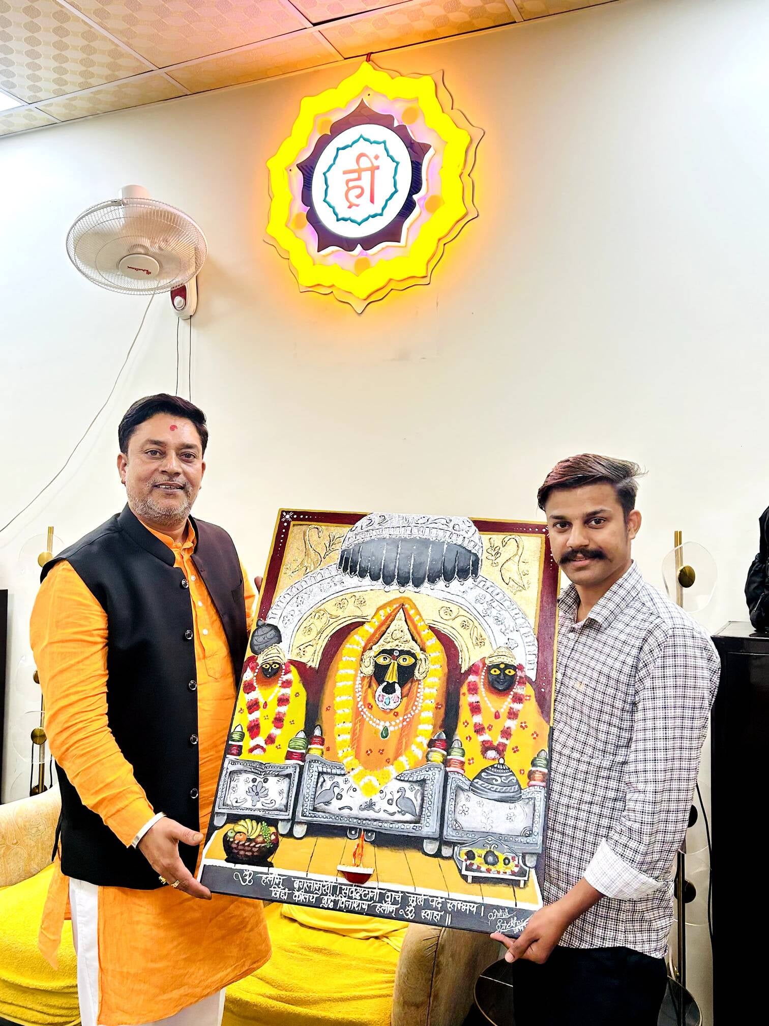 माता बगलामुखी की पेंटिंग को मंदिर के पुजारी को भेंट करते शेखर काठू। जागरूक पाठक