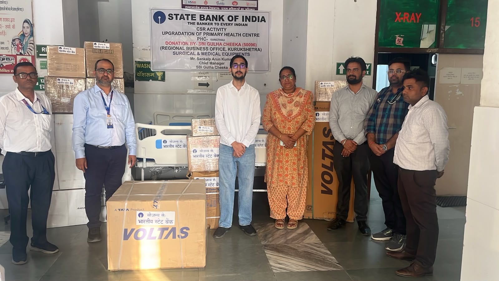 प्राथमिक स्वास्थ्य केंद्रों के लिए सामान भेंट करते बैंक अधिकारी व अन्य। विज्ञप्ति