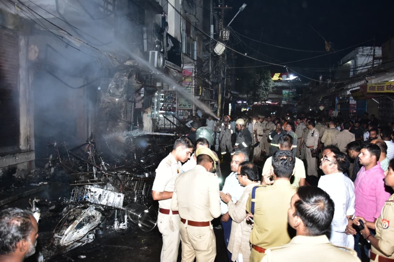 सदर बाजार स्थित ई स्कूटी शोरूम व बर्तन की दुकान से उठतीं लपटें व आग बुझाते दमकल कर्मी।