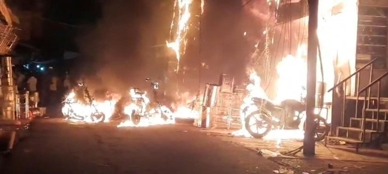 सदर बाजार स्थित ई स्कूटी शोरूम व बर्तन की दुकान से उठतीं लपटें व आग बुझाते दमकल कर्मी।