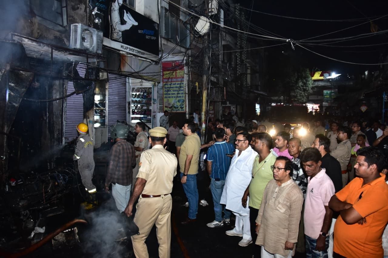 सदर बाजार स्थित ई स्कूटी शोरूम व बर्तन की दुकान से उठतीं लपटें व आग बुझाते दमकल कर्मी।