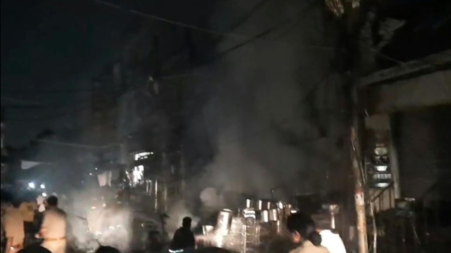 सदर बाजार स्थित ई स्कूटी शोरूम व बर्तन की दुकान से उठतीं लपटें व आग बुझाते दमकल कर्मी।