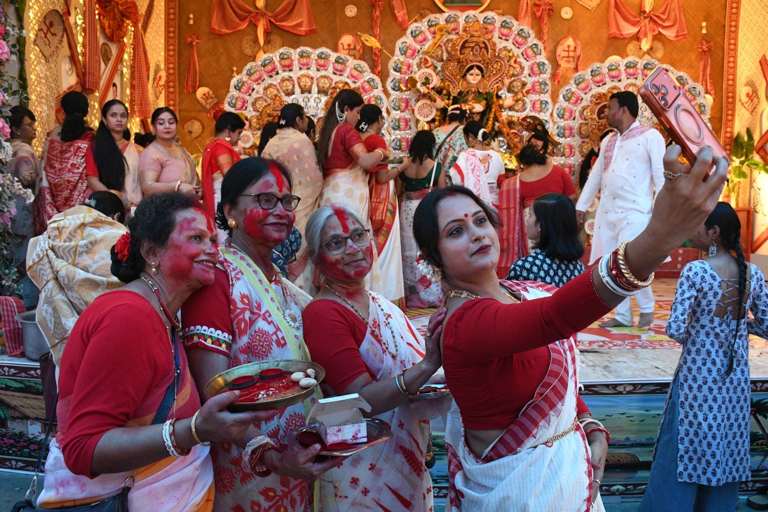 शहर के अलग-अलग पंडालों में सिंदूर खेलतीं महिलाएं। शहर के अलग-अलग पंडालों में सिंदूर खेलतीं महिलाएं।