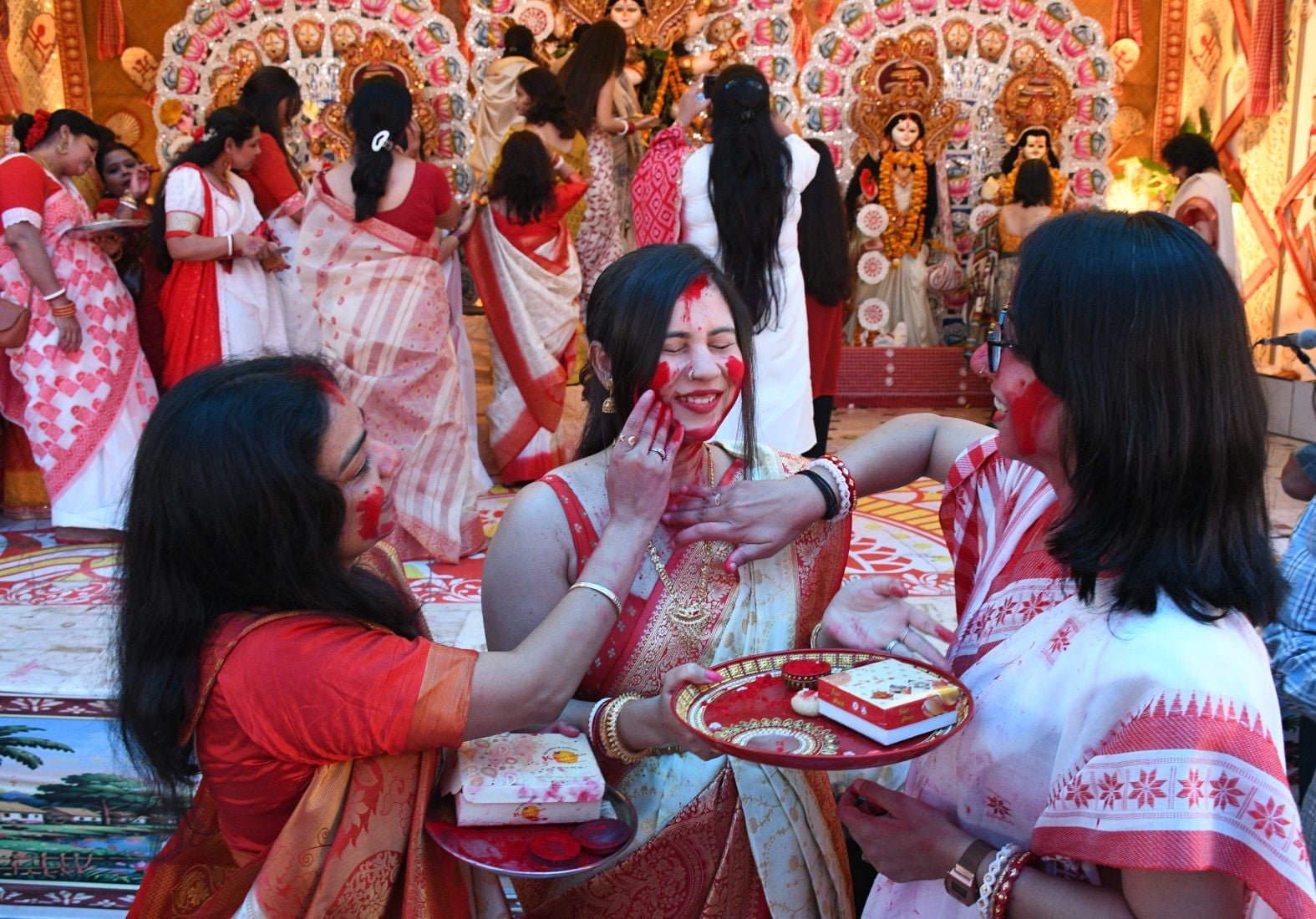 शहर के अलग-अलग पंडालों में सिंदूर खेलतीं महिलाएं। शहर के अलग-अलग पंडालों में सिंदूर खेलतीं महिलाएं।