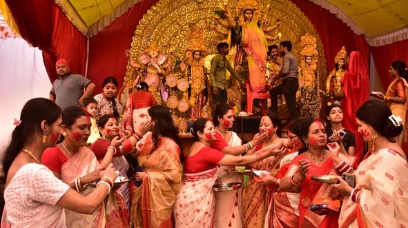 शहर के अलग-अलग पंडालों में सिंदूर खेलतीं महिलाएं। शहर के अलग-अलग पंडालों में सिंदूर खेलतीं महिलाएं।