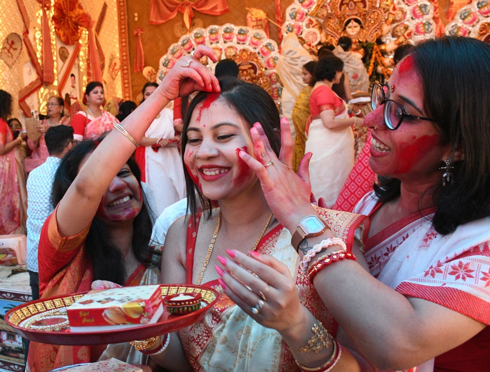शहर के अलग-अलग पंडालों में सिंदूर खेलतीं महिलाएं। शहर के अलग-अलग पंडालों में सिंदूर खेलतीं महिलाएं।