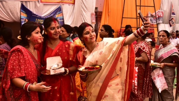 शहर के अलग-अलग पंडालों में सिंदूर खेलतीं महिलाएं। शहर के अलग-अलग पंडालों में सिंदूर खेलतीं महिलाएं।
