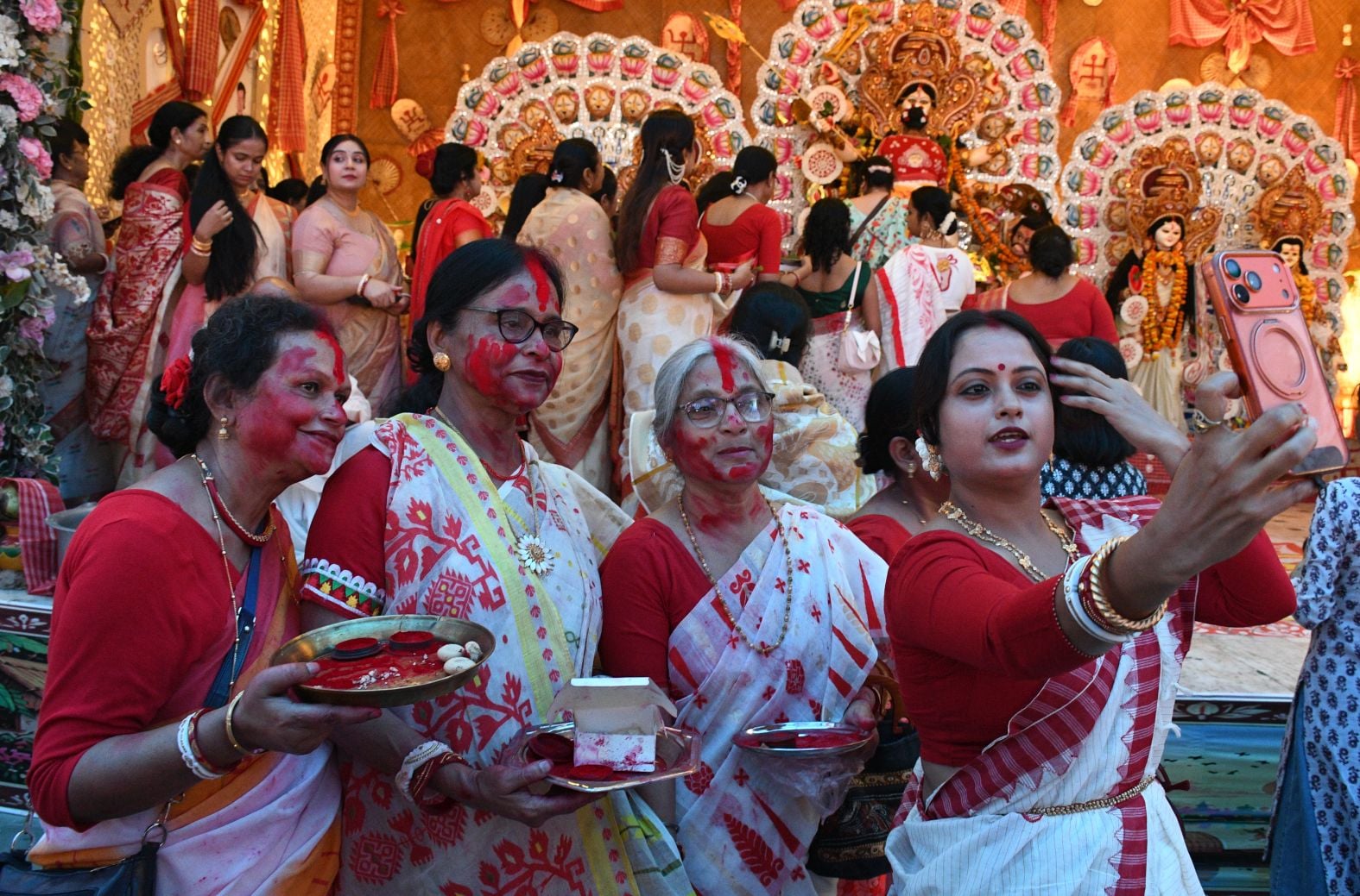 शहर के अलग-अलग पंडालों में सिंदूर खेलतीं महिलाएं। शहर के अलग-अलग पंडालों में सिंदूर खेलतीं महिलाएं।