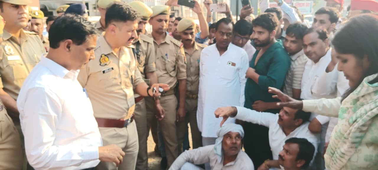 फोटो-19- एरवाकटरा बूथ के बाहर सपाइयों को समझाते थानाध्यक्ष गंगादास गौतम और पीछे खड़े भाजपा नेता