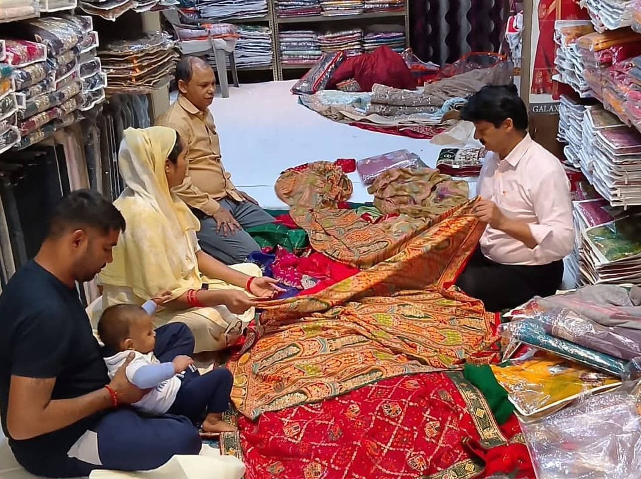 फोटो-12-शहर के चौक बाजार में करवा चौथ को लेकर लहंगा देखती महिला व अन्य। संवाद फोटो-12-शहर के चौक बाजार में करवा चौथ को लेकर लहंगा देखती महिला व अन्य। संवाद